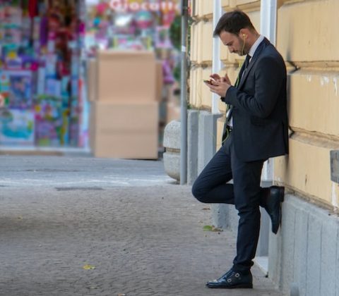 Włoski mężczyzna w garniturze, opierający się o ścianę